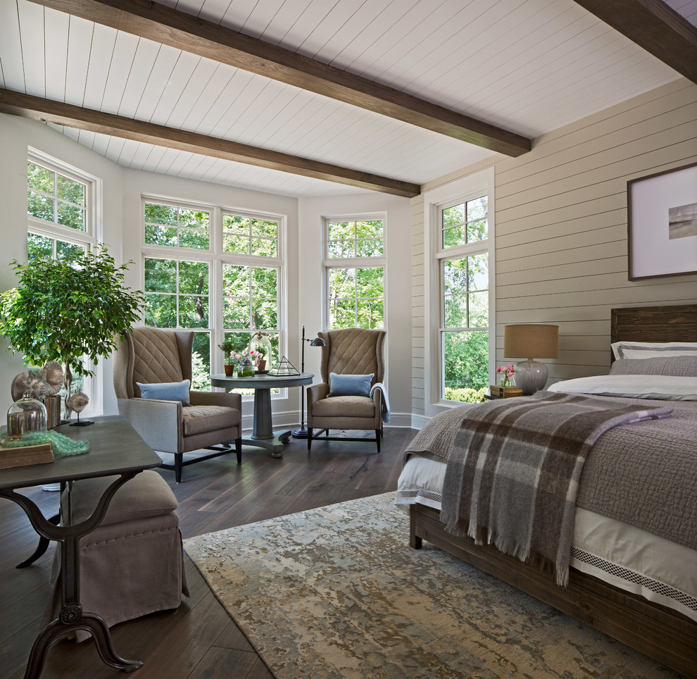 This is an example of a transitional master bedroom in Detroit with beige walls, dark hardwood floors and brown floor.