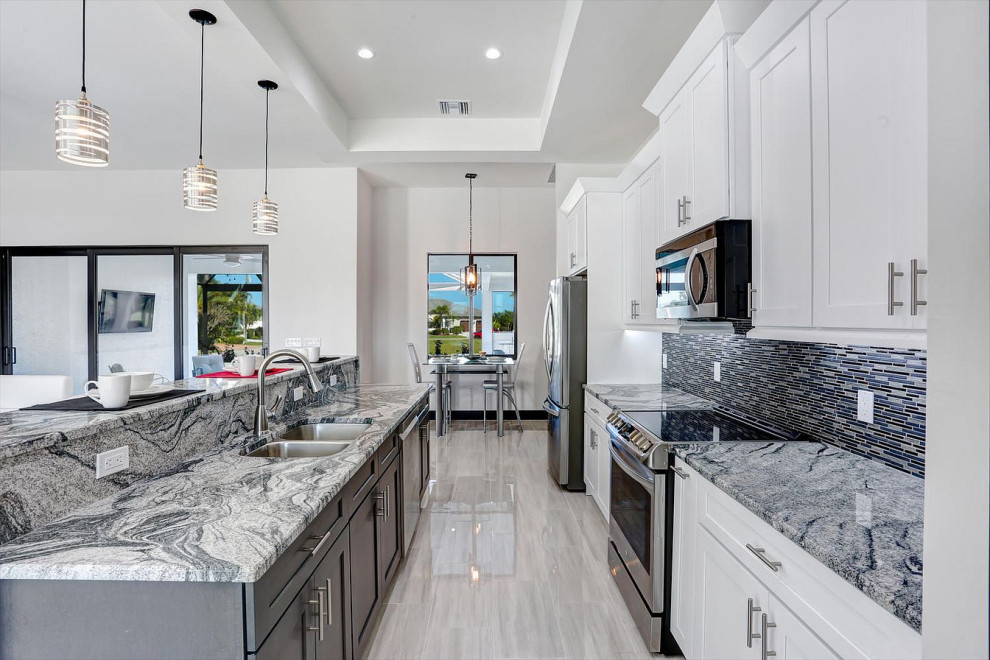 Inspiration for a large transitional galley eat-in kitchen in San Francisco with shaker cabinets, multi-coloured splashback, an undermount sink, white cabinets, matchstick tile splashback, stainless steel appliances, with island, grey floor and grey benchtop.