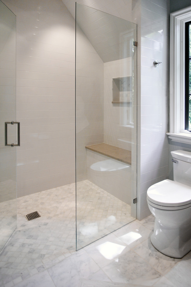 Traditional bathroom in Atlanta with a curbless shower, white tile and marble floors.