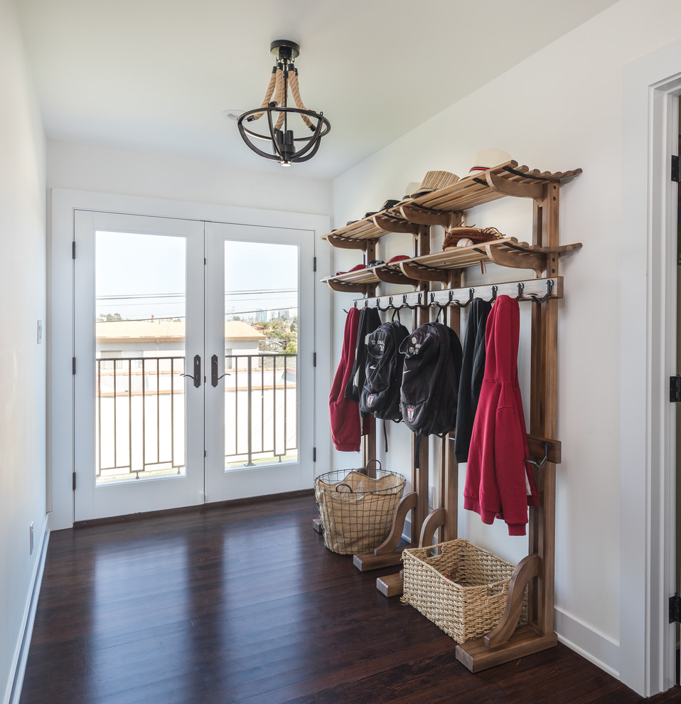 Design ideas for a country mudroom in Los Angeles with white walls, dark hardwood floors, a double front door, a glass front door and brown floor.