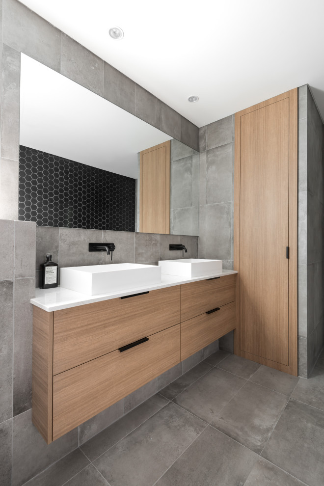Photo of a contemporary master bathroom in Perth with flat-panel cabinets, medium wood cabinets, gray tile, a vessel sink, grey floor, white benchtops, a double vanity and a floating vanity.