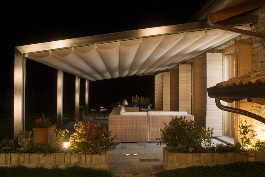 Inspiration for a mid-sized contemporary backyard verandah in Indianapolis with natural stone pavers and an awning.