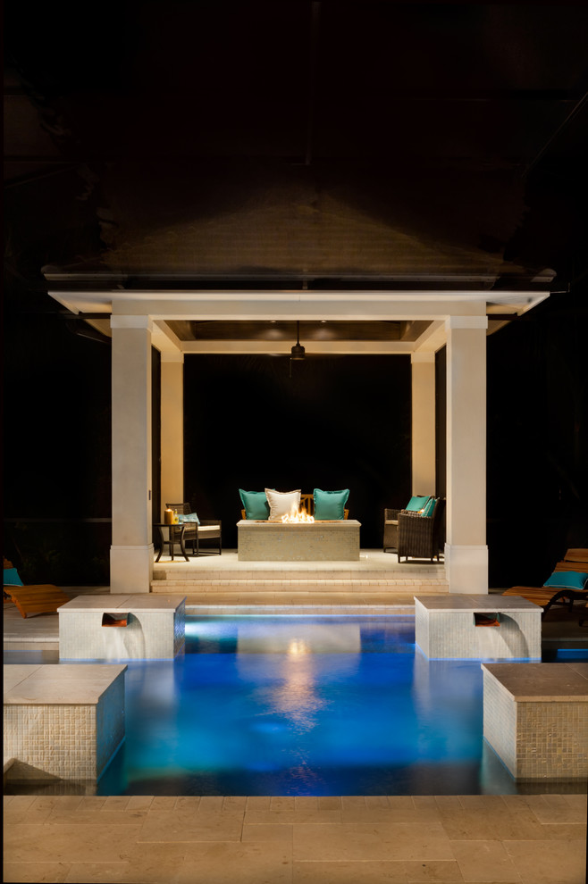 Inspiration for a large contemporary backyard custom-shaped pool in Tampa with natural stone pavers.