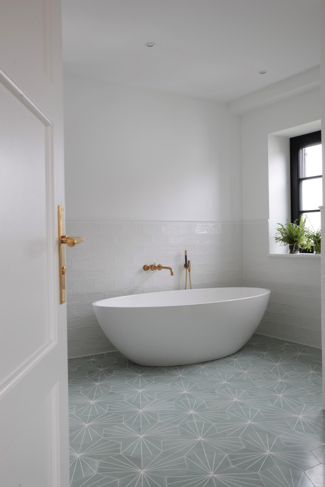 Photo of a mid-sized traditional bathroom in Munich with a freestanding tub, white tile, ceramic tile, cement tiles and green floor.