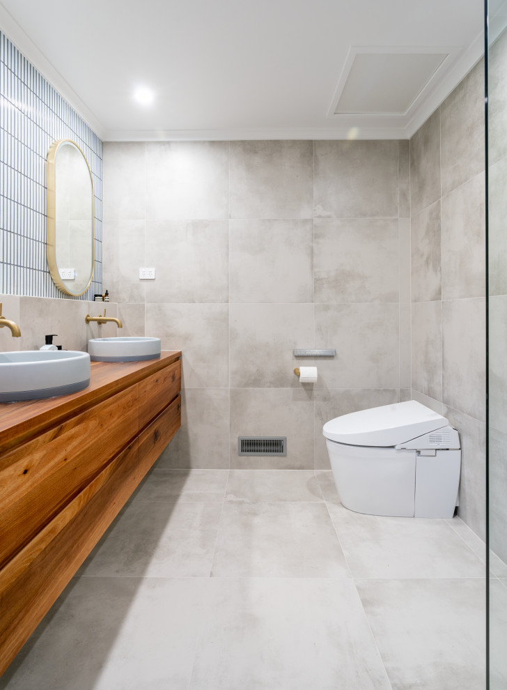 Imagen de cuarto de baño principal, doble y flotante retro de tamaño medio con puertas de armario azules, baldosas y/o azulejos grises, paredes grises y encimera de madera