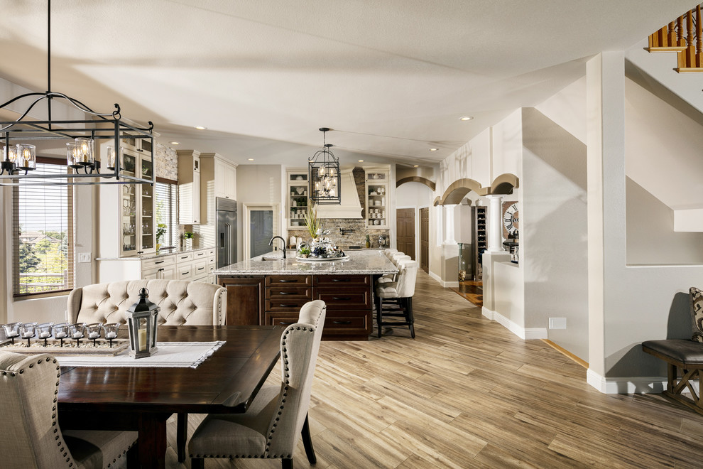 Large transitional l-shaped porcelain tile and brown floor eat-in kitchen photo in Orlando with an undermount sink, raised-panel cabinets, beige cabinets, quartz countertops, multicolored backsplash, travertine backsplash, stainless steel appliances, an island and multicolored countertops