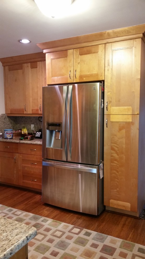 Example of a transitional kitchen design with shaker cabinets, light wood cabinets and granite countertops