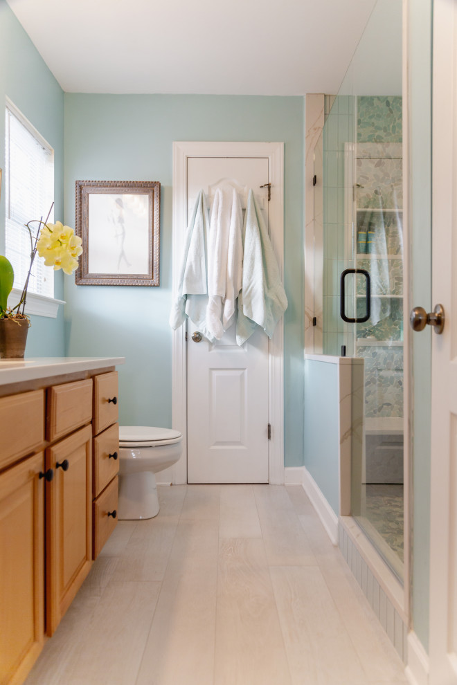 Small beach style master bathroom in Charleston with raised-panel cabinets, light wood cabinets, an alcove shower, a two-piece toilet, green tile, porcelain tile, green walls, porcelain floors, an undermount sink, engineered quartz benchtops, beige floor, a hinged shower door, white benchtops, a shower seat, a single vanity and a built-in vanity.