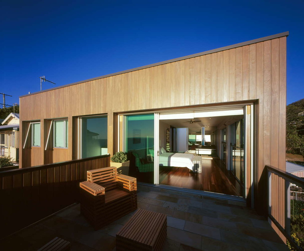 This is an example of a contemporary two-storey white exterior in Gold Coast - Tweed with wood siding and a flat roof.