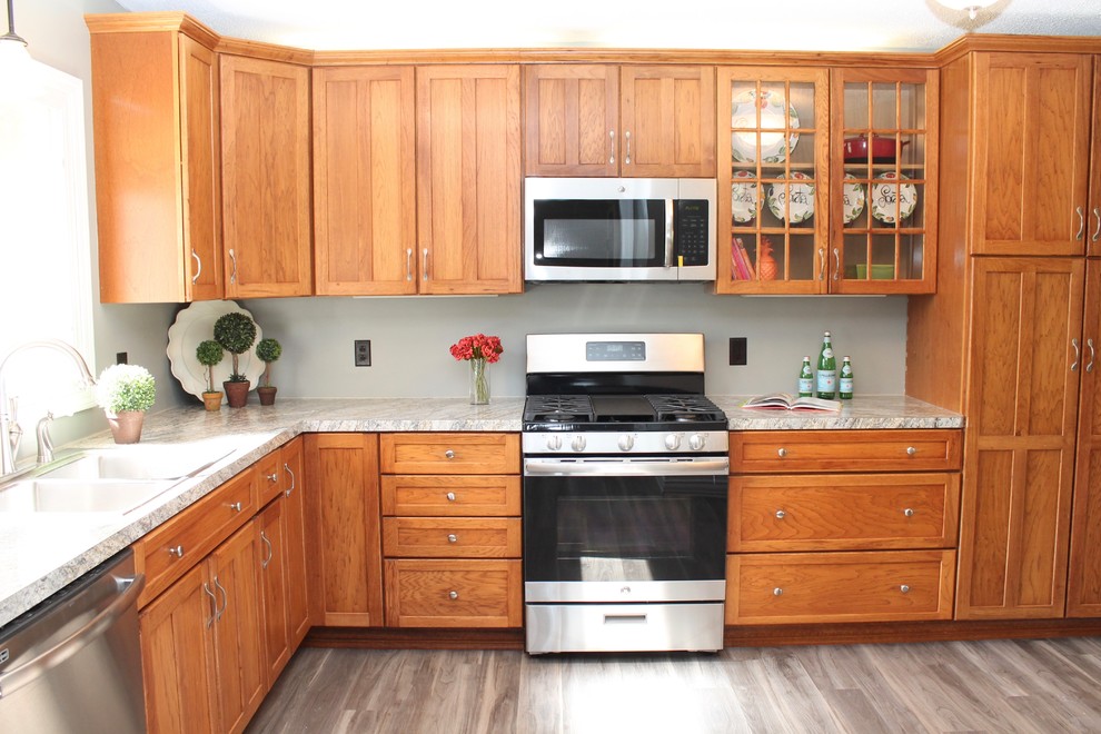 Large transitional l-shaped medium tone wood floor and gray floor enclosed kitchen photo in New York with glass-front cabinets, medium tone wood cabinets and stainless steel appliances