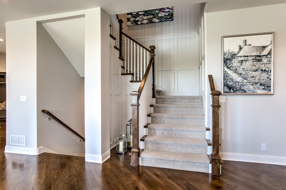 Inspiration for a large transitional carpeted u-shaped staircase in Omaha with wood railing and carpet risers.