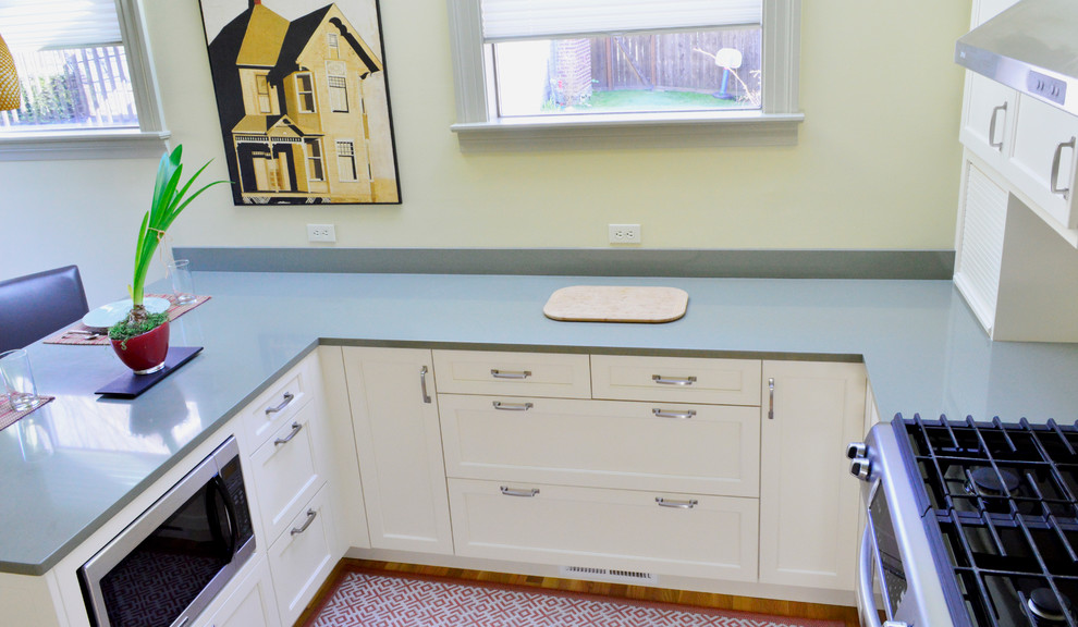 Inspiration for a mid-sized transitional light wood floor enclosed kitchen remodel in Seattle with an undermount sink, recessed-panel cabinets, white cabinets, quartz countertops, white backsplash, subway tile backsplash, stainless steel appliances and a peninsula