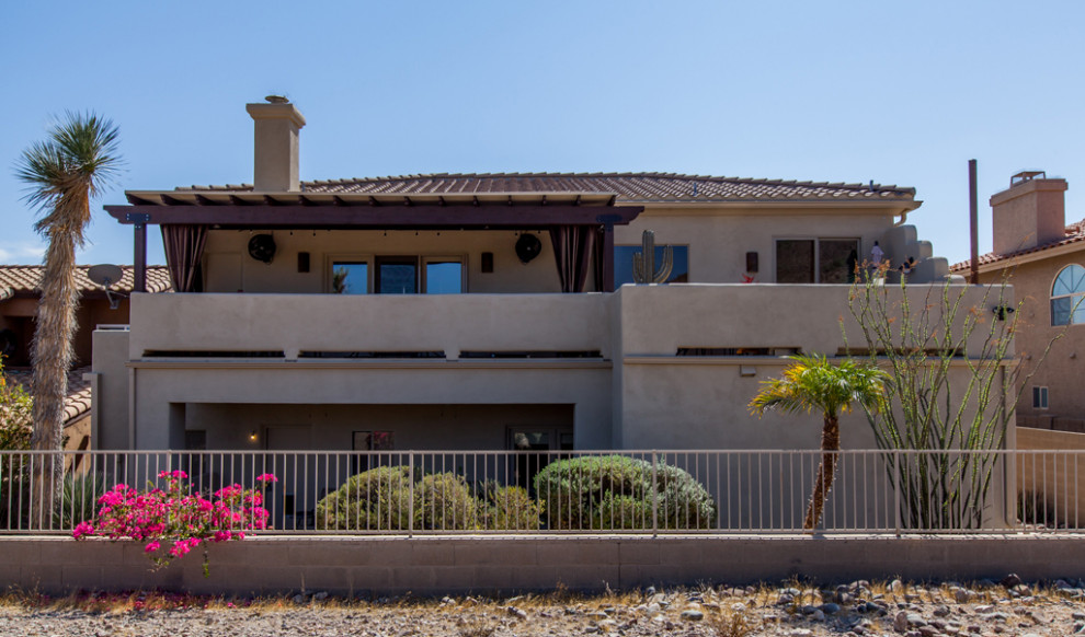 Large southwestern two-story stucco house exterior idea in Phoenix with a tile roof and a brown roof
