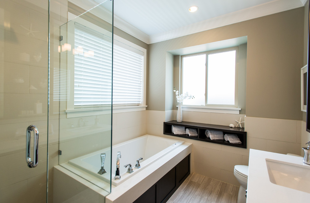 Photo of a mid-sized modern master bathroom in Vancouver with engineered quartz benchtops, an alcove tub, a corner shower, a one-piece toilet, beige tile, ceramic tile, beige walls and ceramic floors.
