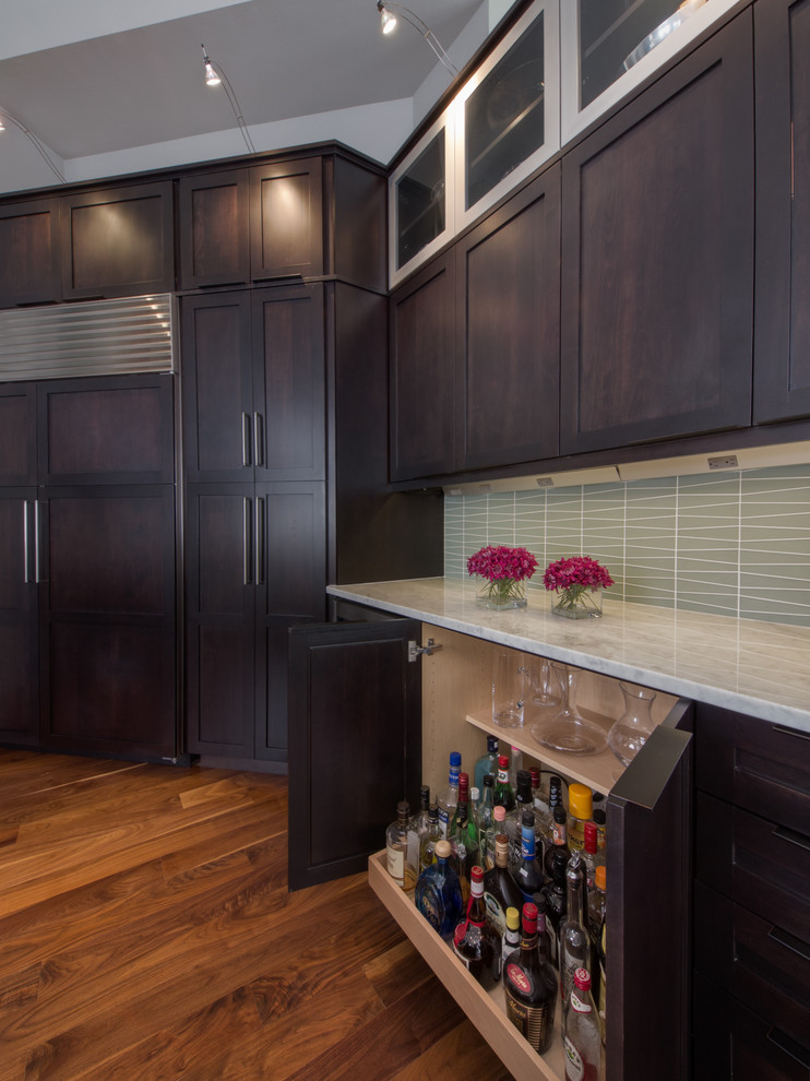 This is an example of a contemporary kitchen in Denver with shaker cabinets, dark wood cabinets, marble benchtops, blue splashback, glass tile splashback and stainless steel appliances.