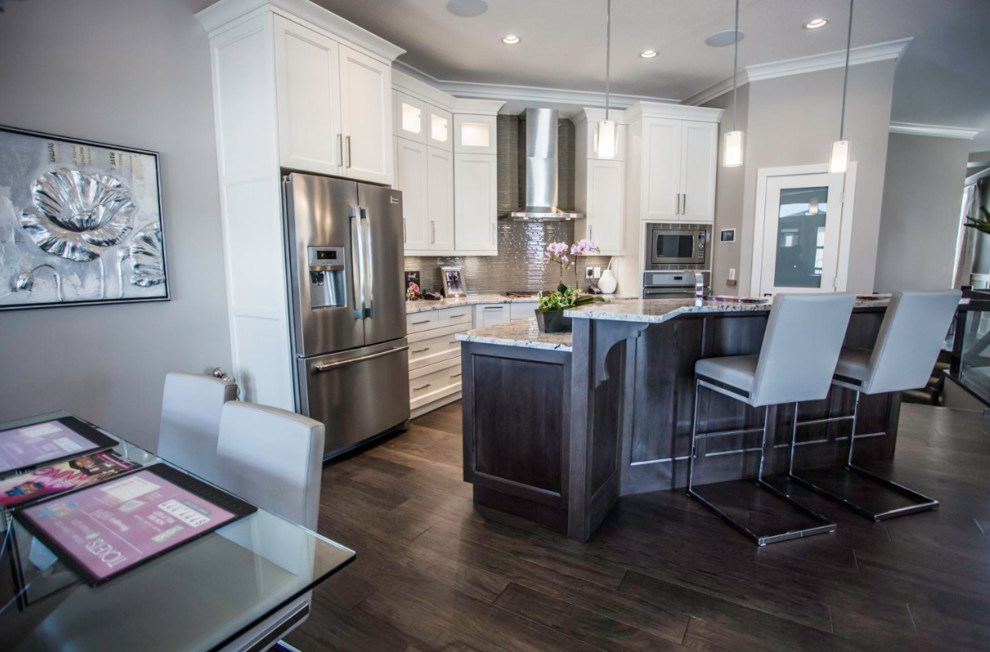 Inspiration for a large transitional single-wall medium tone wood floor open concept kitchen remodel with an undermount sink, shaker cabinets, white cabinets, granite countertops, brown backsplash, stainless steel appliances and an island