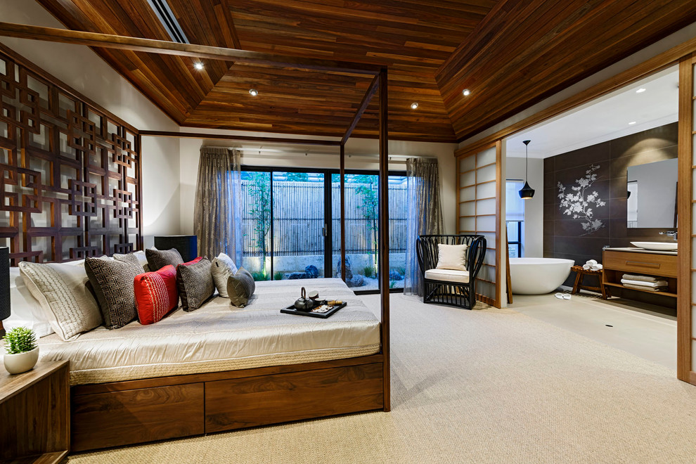 This is an example of a large asian master bedroom in Perth with beige walls, carpet and no fireplace.