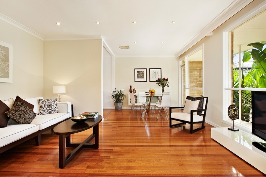 This is an example of a modern open concept living room in Melbourne with white walls, light hardwood floors and brown floor.