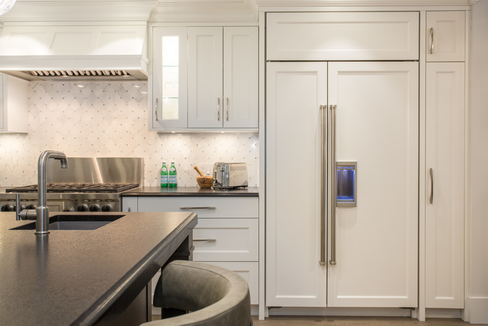 Large transitional l-shaped medium tone wood floor and beige floor eat-in kitchen photo in Vancouver with an undermount sink, shaker cabinets, white cabinets, granite countertops, gray backsplash, marble backsplash, stainless steel appliances, an island and black countertops
