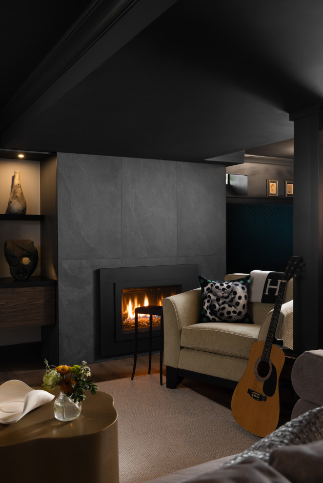 Example of a small trendy underground vinyl floor, brown floor and wallpaper basement design in Detroit with a bar, black walls, a standard fireplace and a stone fireplace