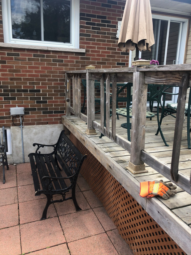 Example of a mid-sized backyard deck design in Toronto with no cover