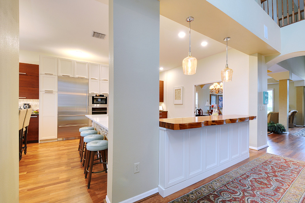Inspiration for a large transitional l-shaped dark wood floor open concept kitchen remodel in Tampa with a farmhouse sink, gray backsplash, matchstick tile backsplash, stainless steel appliances and an island