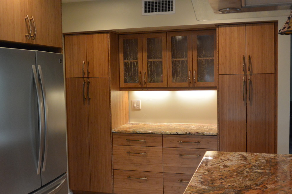 Inspiration for a transitional u-shaped porcelain tile and beige floor eat-in kitchen remodel with an undermount sink, flat-panel cabinets, light wood cabinets, granite countertops, stainless steel appliances, a peninsula and brown countertops