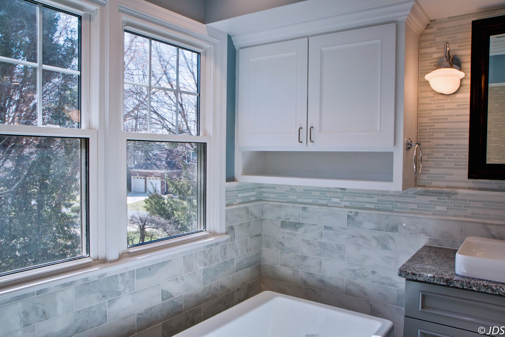 Design ideas for a mid-sized transitional master bathroom in DC Metro with a drop-in sink, raised-panel cabinets, grey cabinets, granite benchtops, a freestanding tub, an open shower, a two-piece toilet, white tile, stone tile, blue walls and ceramic floors.
