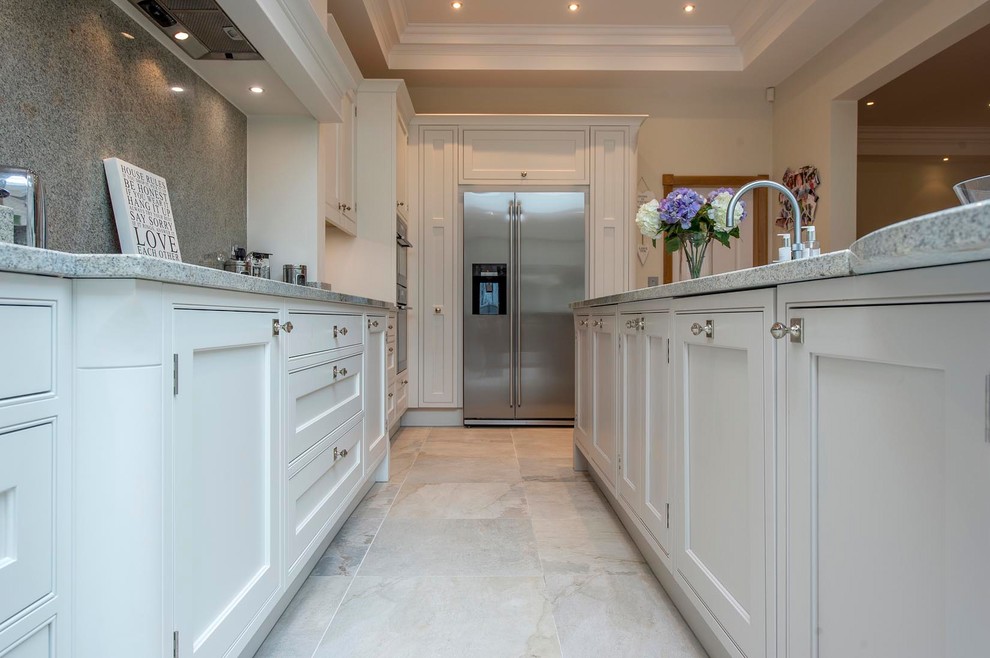 Photo of a large traditional l-shaped open plan kitchen in Other with an undermount sink, shaker cabinets, beige cabinets, granite benchtops, multi-coloured splashback, stainless steel appliances and with island.