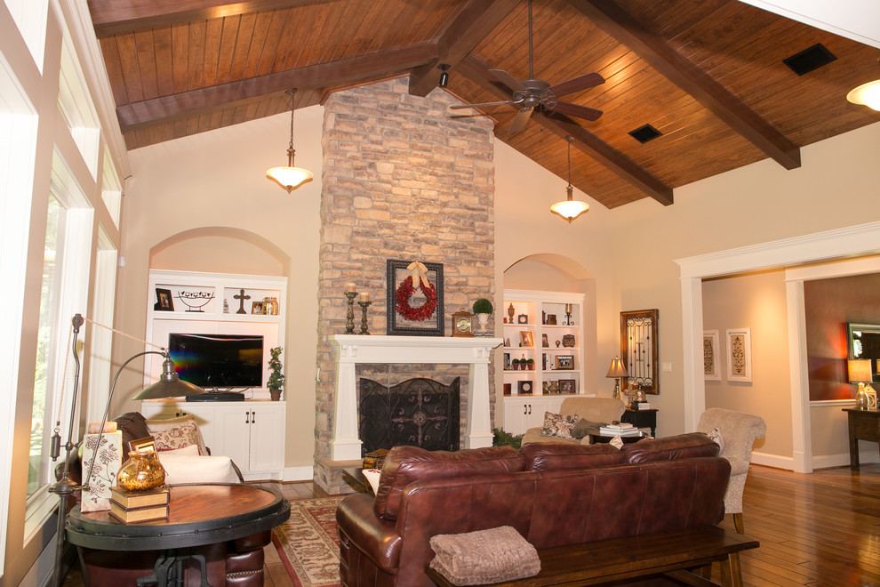 Mid-sized arts and crafts formal open concept living room in Houston with beige walls, a standard fireplace, a stone fireplace surround, a built-in media wall and medium hardwood floors.
