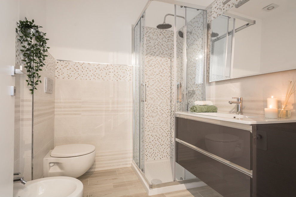 This is an example of a small scandinavian powder room in Milan with flat-panel cabinets, brown cabinets, a wall-mount toilet, beige tile, porcelain tile, white walls, porcelain floors, a drop-in sink, marble benchtops, beige floor and white benchtops.