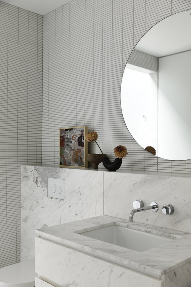 Стильный дизайн: ванная комната в стиле модернизм с плоскими фасадами, белыми фасадами, белой плиткой, плиткой мозаикой, врезной раковиной, белой столешницей, тумбой под одну раковину и подвесной тумбой - последний тренд
