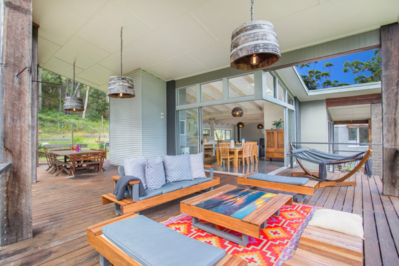 Photo of a large country backyard patio in Sydney with a fire feature, decking and a roof extension.
