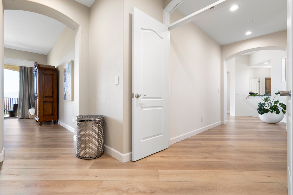 Inspiration for a mid-sized modern vinyl floor and beige floor hallway remodel in Phoenix with white walls