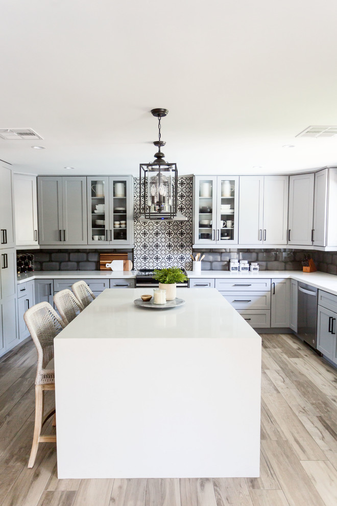 Eat-in kitchen - mid-sized transitional u-shaped light wood floor and gray floor eat-in kitchen idea in Phoenix with an undermount sink, recessed-panel cabinets, gray cabinets, quartz countertops, multicolored backsplash, ceramic backsplash, stainless steel appliances, an island and white countertops