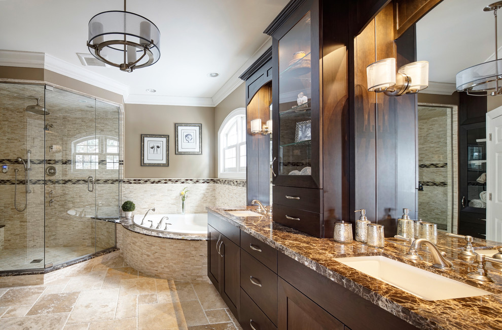 Example of a large transitional master beige tile travertine floor drop-in bathtub design in Chicago with an undermount sink, furniture-like cabinets, dark wood cabinets, marble countertops, a two-piece toilet and beige walls