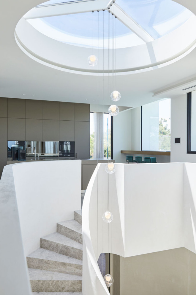 This is an example of an expansive modern limestone spiral staircase in Melbourne with limestone risers.
