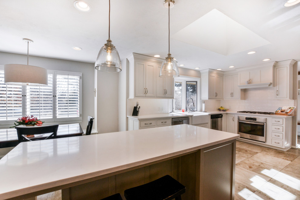 Transitional kitchen photo with white cabinets and an island