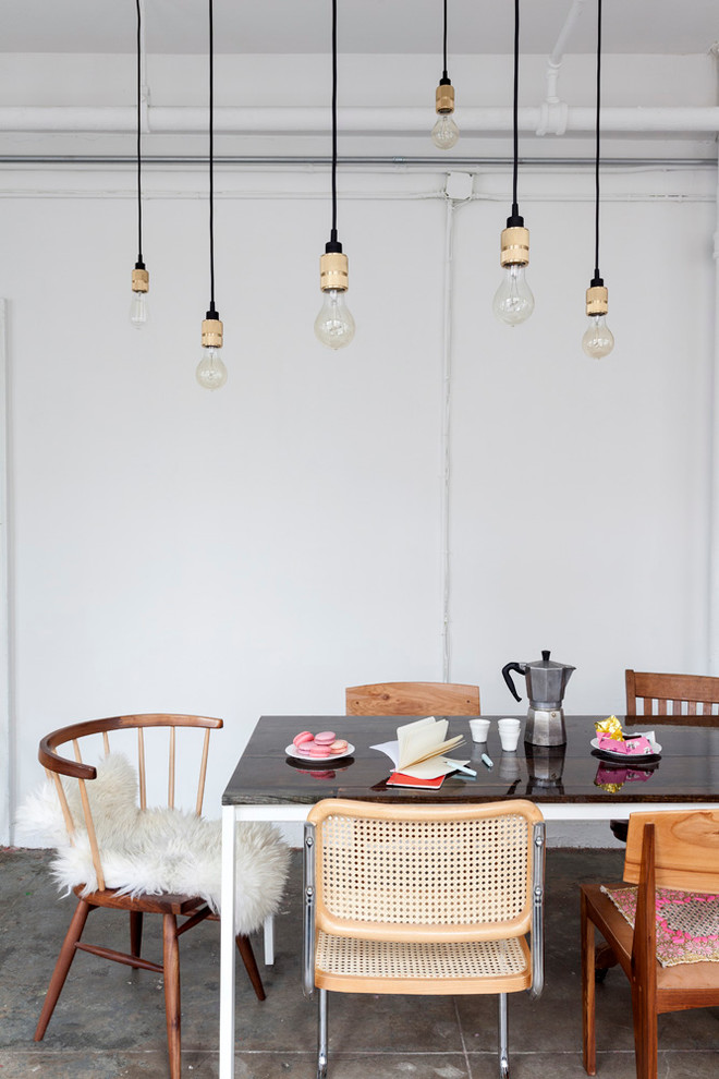 Industrial dining room in New York with white walls and concrete floors.