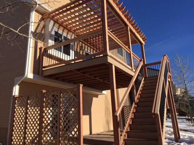 Large elegant backyard deck photo in Denver with a pergola