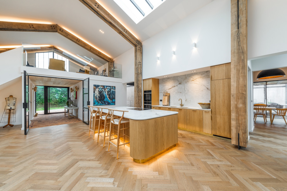 Inspiration for a large country open plan kitchen in Devon with medium wood cabinets, solid surface benchtops, white splashback, medium hardwood floors, with island, brown floor, white benchtop and exposed beam.