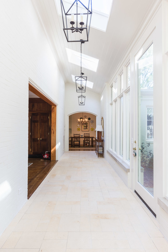 Design ideas for a large midcentury hallway in Nashville with white walls and travertine floors.
