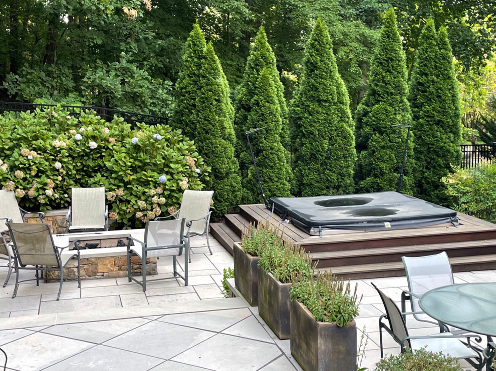 Design ideas for a medium sized modern back patio in DC Metro with a fire feature and natural stone paving.