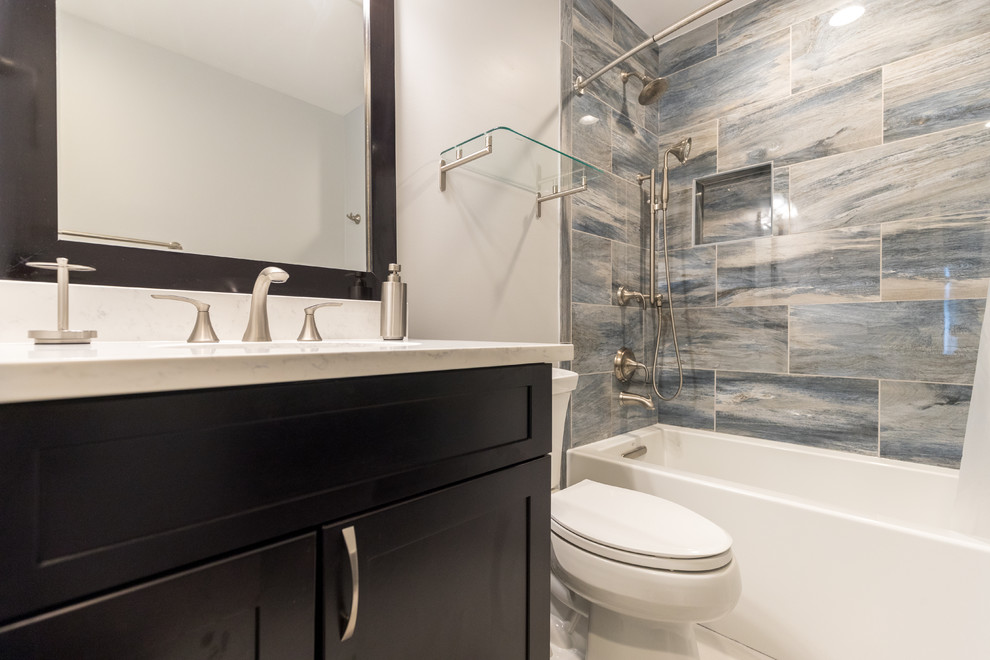 Inspiration for a mid-sized transitional master bathroom in DC Metro with shaker cabinets, dark wood cabinets, an alcove tub, a shower/bathtub combo, a two-piece toilet, multi-coloured tile, porcelain tile, grey walls, an undermount sink, quartzite benchtops and a shower curtain.