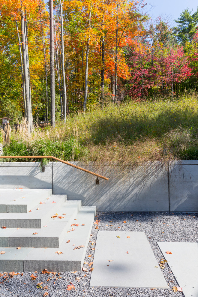 Mid-sized contemporary sloped partial sun xeriscape in New York with a garden path and natural stone pavers for fall.