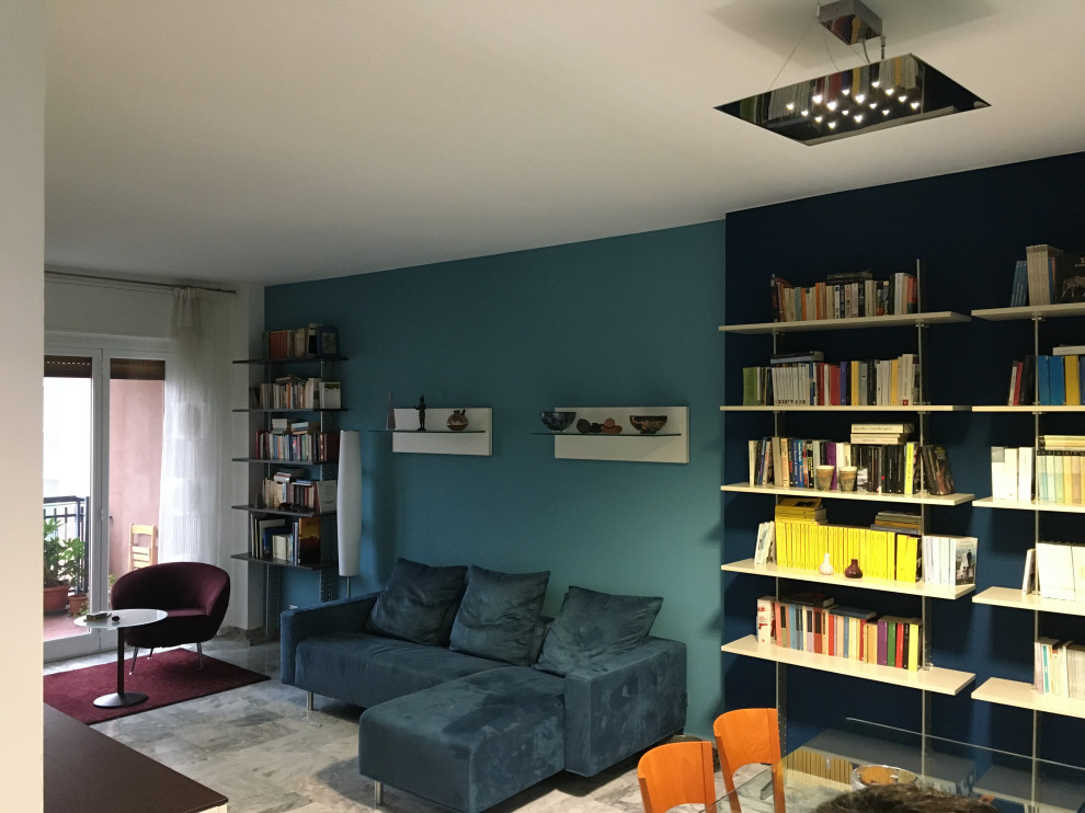 Photo of a contemporary open concept living room in Milan with a library, blue walls, marble floors and grey floor.