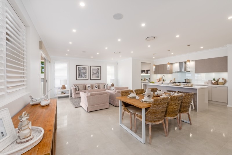 This is an example of a large beach style open plan dining in Newcastle - Maitland with white walls, porcelain floors, no fireplace and beige floor.