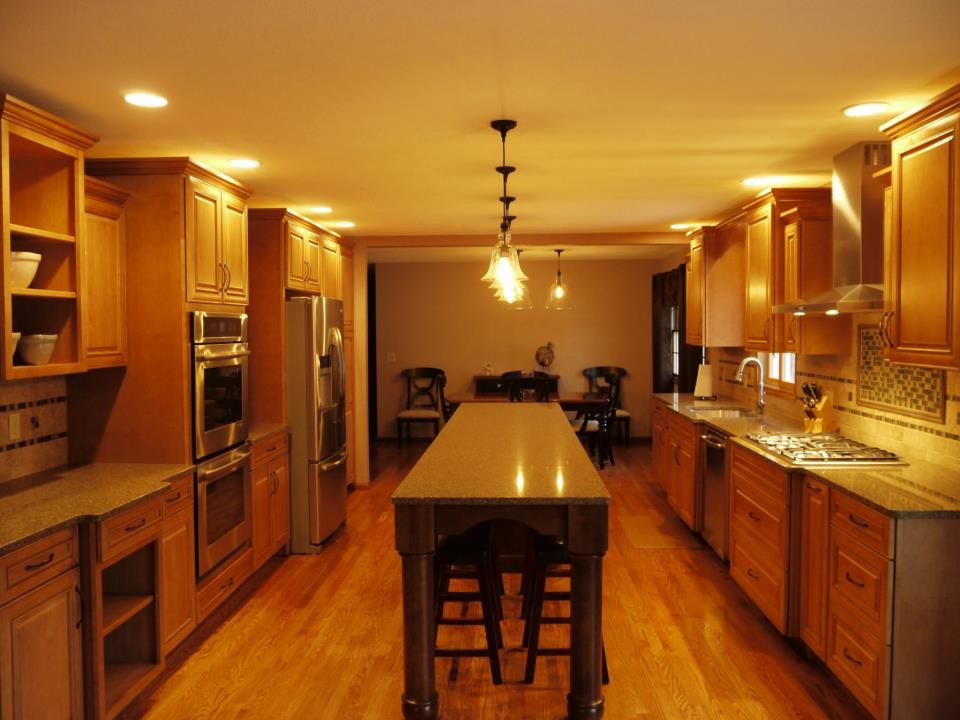 Inspiration for a large transitional galley kitchen remodel in Grand Rapids with an undermount sink, raised-panel cabinets, dark wood cabinets, granite countertops, multicolored backsplash, stainless steel appliances and an island
