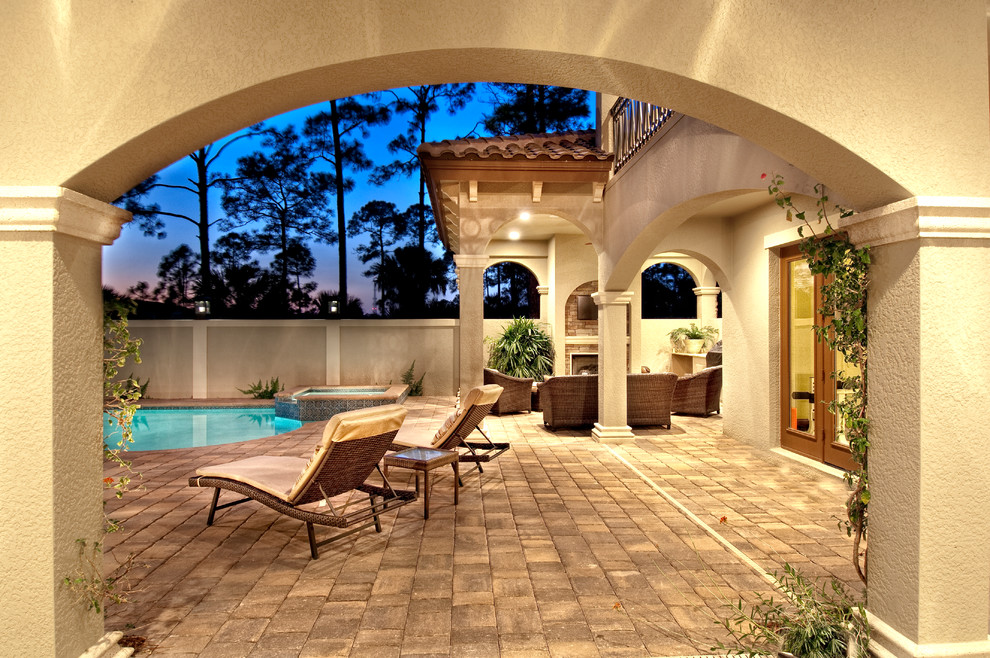 Large mediterranean courtyard patio in Miami with a water feature, concrete pavers and a roof extension.
