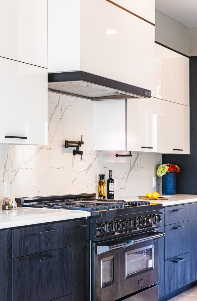 Inspiration for a large modern galley open plan kitchen in DC Metro with a drop-in sink, flat-panel cabinets, white cabinets, quartz benchtops, white splashback, engineered quartz splashback, black appliances, marble floors, with island, beige floor and white benchtop.